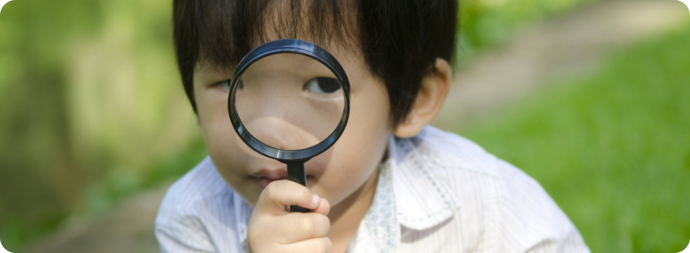 boy holding a magnifying glass